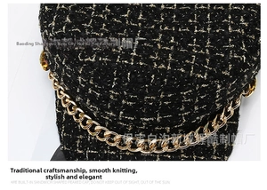Detailed close-up of tweed beret featuring gold thread weave and metallic chain decoration