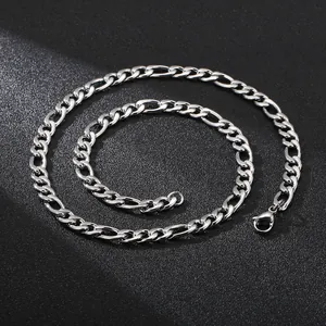 Silver Figaro chain necklace in classic link style for men on black textured background