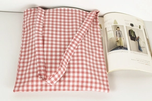 Detail of red and white gingham cotton tote bag with a minimalist lifestyle aesthetic