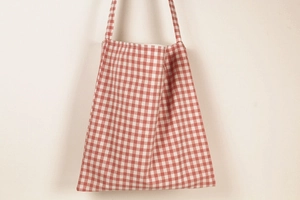 Detail of red plaid canvas tote bag showing large capacity for daily essentials