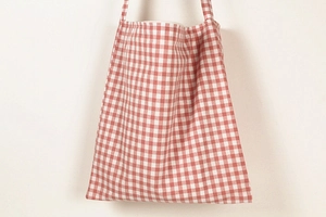 Close-up of red and white gingham canvas bag fabric and durable shoulder strap detail