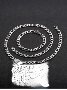 Macro view of silver Figaro chain necklace and bracelet set with lobster clasp detail