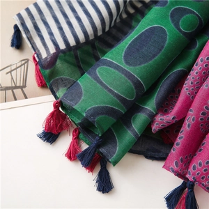 Detail of ethnic floral cotton linen scarves featuring vibrant patterns and tassel edges