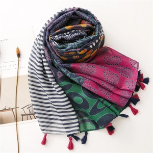 Detail of colorful cotton linen scarf with ethnic floral patterns and red-blue fringe tassels