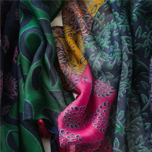 Detail of ethnic floral cotton linen scarf featuring colorful patterns and fine fringes