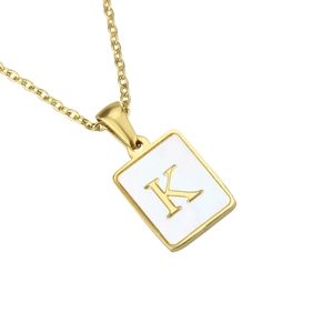 Detailed macro view of a gold square shell pendant featuring a metallic letter K engraving