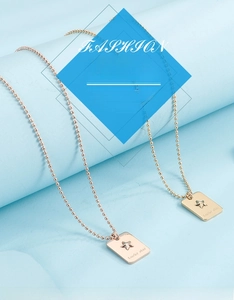 Détail du collier à billes dorées avec pendentif rectangulaire gravé Lucky Star