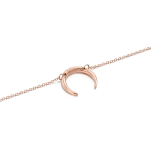 Detail of rose gold crescent necklace showing textured hammered finish on the horn pendant