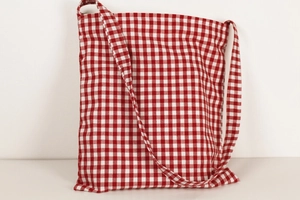 Detail of red and white gingham cotton linen shoulder bag with natural fabric texture