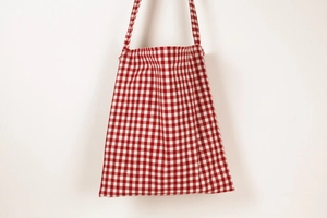 Close-up of red gingham cotton tote bag showing fabric texture and shoulder strap