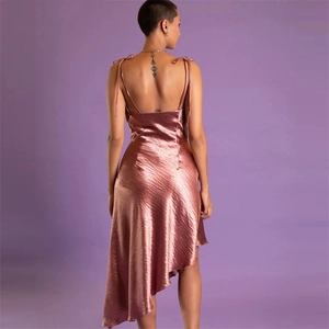 Robe sexy en satin or rose dos nu avec ourlet irrégulier sur fond violet élégant