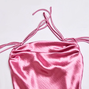 Détail d'une robe en satin rose avec un col bénitier drapé et de fines bretelles délicates