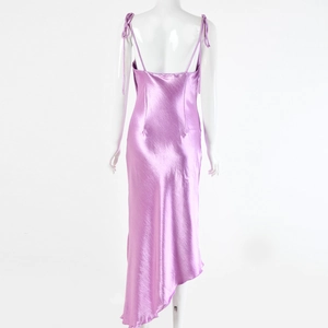 Vue détaillée d'une robe en satin violette avec bretelles croisées et ourlet asymétrique