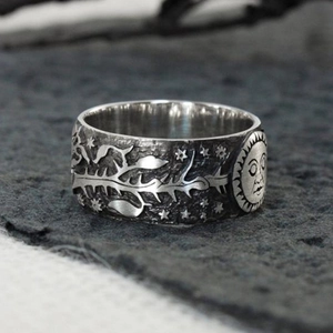 Dettaglio macro dell'anello in argento vintage con motivi a rilievo di sole e stelle