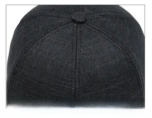 Detail of high-quality stitching and top button on a navy blue canvas baseball cap