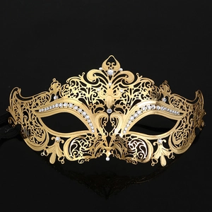 Macro shot of gold metal filigree mask with sparkling rhinestones for masquerade parties