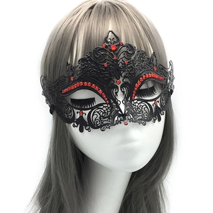 Macro detail of black metal masquerade mask with red rhinestones and butterfly wings