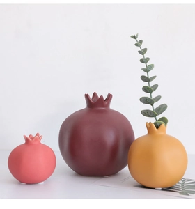 Dettaglio di vasi in ceramica a forma di melograno con finitura opaca rossa rosa e gialla