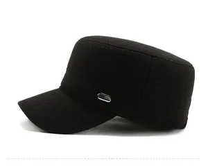 Detail of black military style flat cap showing side texture and metal logo badge