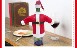 Detail of Santa Claus wine bottle cover set on a green bottle for Christmas table decor