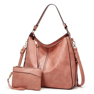 Detailed view of pink leather tote bag with matching pouch and adjustable shoulder strap