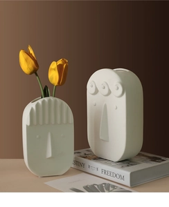 Detail of two matte white ceramic face vases with Nordic abstract minimalist design