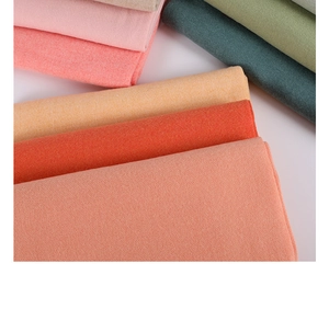Close-up of stacked colorful cashmere scarves showing soft fabric texture and fringe