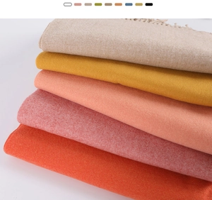 Detailed macro view of soft cashmere scarf layers with fringe in various Morandi colors