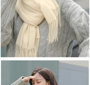 Close-up of beige knit scarf with tassels showing soft cashmere-like texture on model