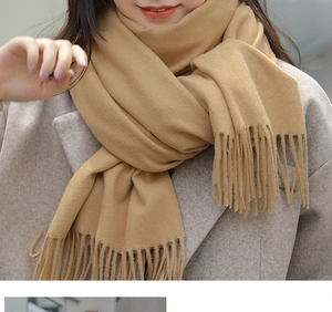 Close-up of soft camel cashmere pashmina shawl showing fine tassel detail and texture