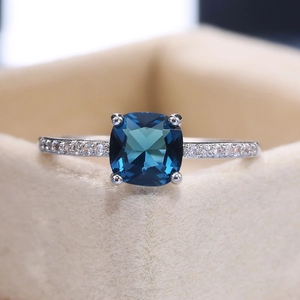 Macro shot of square blue sapphire ring with pave zircon details in a velvet box