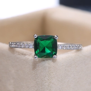 Macro shot of square-cut emerald green zircon ring with side micro-pave detailing