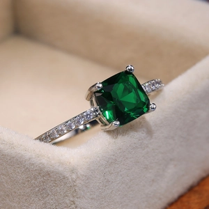 Detailed close-up of emerald-cut blue square stone ring with micro-pave cubic zirconia