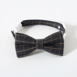 Close-up of grey herringbone fabric texture and white plastic buckle on pet bowtie collar
