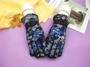 Detail of blue camouflage ski gloves for kids featuring an adjustable wrist strap for wind protection