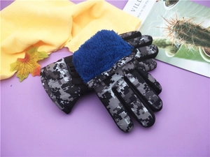 Close-up of waterproof camouflage ski gloves with warm blue plush cuffs for children