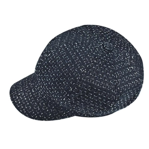 Detail of dark grey plaid tweed newsboy cap showing textured fabric and vintage style