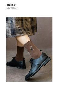 Detail von dunkelbraunen Baumwollsocken mit Stickerei kombiniert mit Retroschuhen