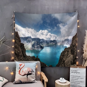 Detailed view of nature landscape tapestry hanging over a cozy sofa with fairy lights