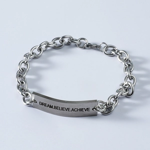 Close-up of silver steel bracelet engraved with DREAM BELIEVE ACHIEVE on plate