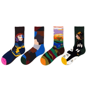 Flat lay of four pairs of artistic socks with colorful patterns and professional white background