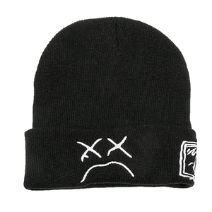Bonnet en tricot noir minimaliste avec visage brodé blanc et détail de patch latéral