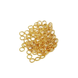 Golden open jump rings for DIY jewelry making in a stack on white background