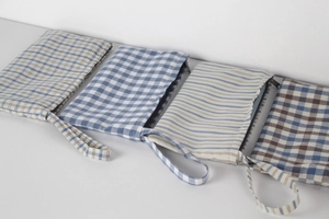 Close-up of assorted light blue plaid and striped linen pouches with zipper and wrist straps
