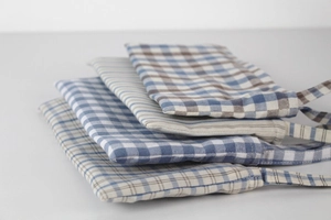Close-up of assorted plaid and striped cotton linen storage bags in blue and grey hues