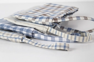 Detail of light blue checkered and striped linen cotton fabric phone pouch with handle