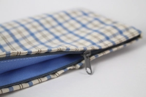 Blue plaid linen storage bag with zipper closure and soft cotton fabric texture