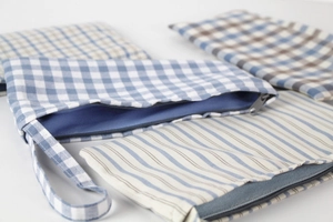 Detail view of cotton linen pouches showing blue plaid and striped fabric textures