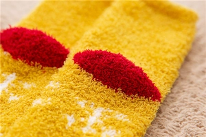 Macro shot of warm yellow coral fleece socks showcasing thick and soft fuzzy texture