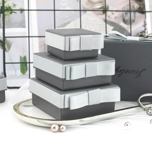 Macro shot of grey jewelry boxes with ribbon bows and textured finish in multiple sizes